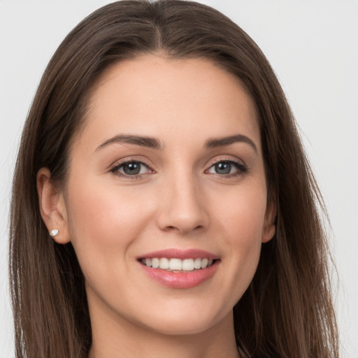 Joyful white young-adult female with long  brown hair and grey eyes