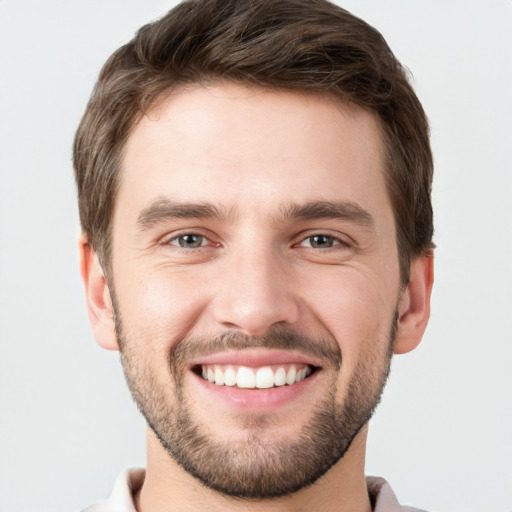 Joyful white young-adult male with short  brown hair and grey eyes