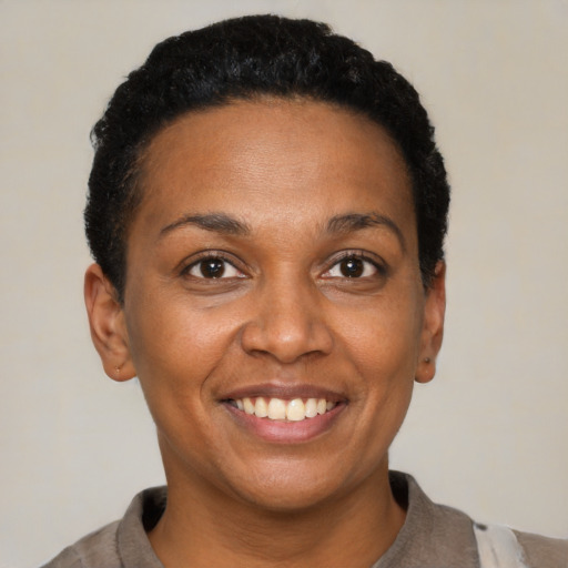 Joyful black young-adult female with short  brown hair and brown eyes
