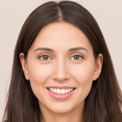 Joyful white young-adult female with long  brown hair and brown eyes