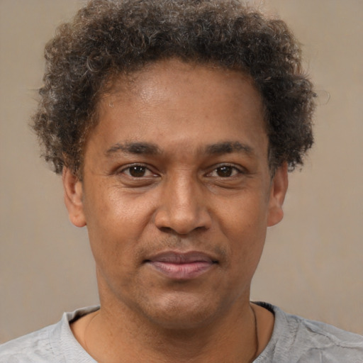 Joyful latino adult male with short  brown hair and brown eyes