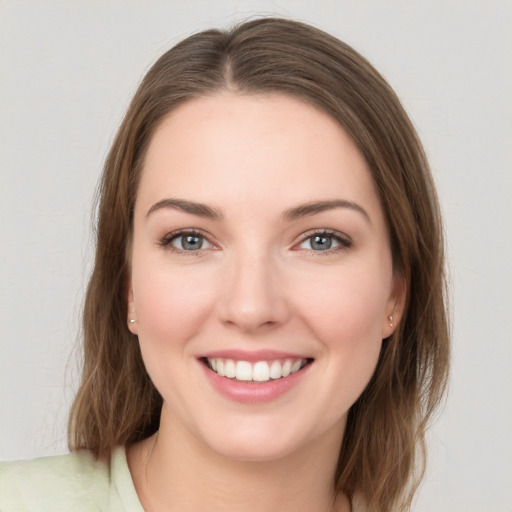 Joyful white young-adult female with medium  brown hair and green eyes