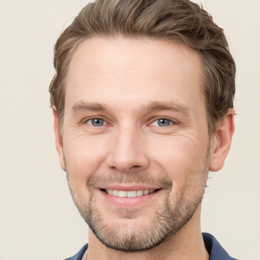 Joyful white adult male with short  brown hair and grey eyes