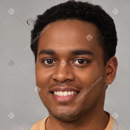 Joyful black young-adult male with short  brown hair and brown eyes