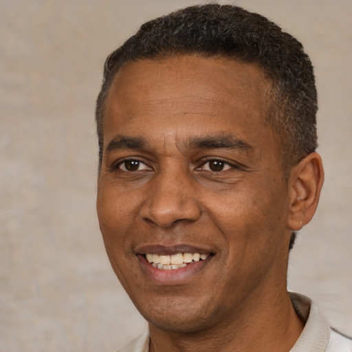 Joyful black adult male with short  brown hair and brown eyes