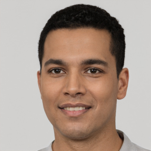 Joyful latino young-adult male with short  black hair and brown eyes