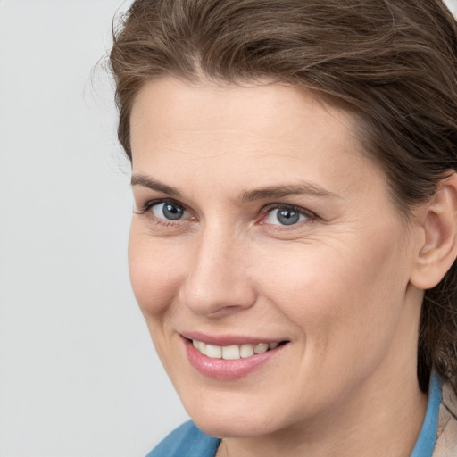 Joyful white young-adult female with medium  brown hair and blue eyes