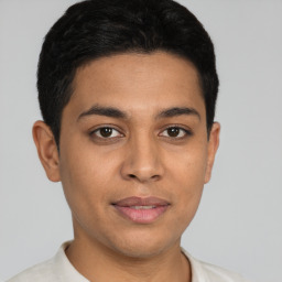 Joyful latino young-adult male with short  black hair and brown eyes