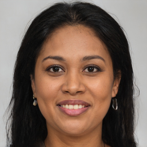 Joyful latino adult female with long  brown hair and brown eyes