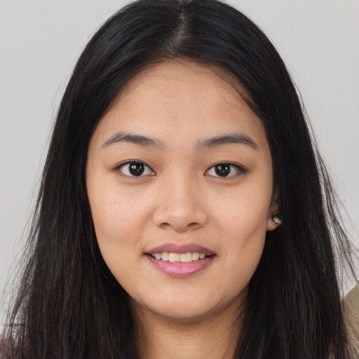Joyful asian young-adult female with long  brown hair and brown eyes