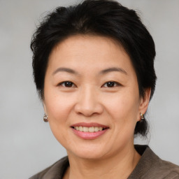 Joyful asian adult female with short  brown hair and brown eyes