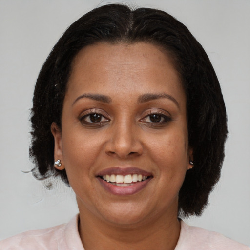 Joyful black adult female with medium  brown hair and brown eyes