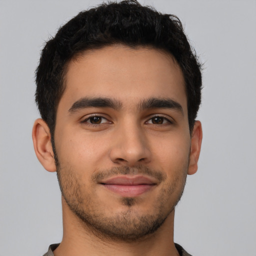 Joyful latino young-adult male with short  brown hair and brown eyes