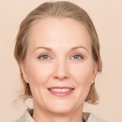 Joyful white adult female with medium  brown hair and grey eyes