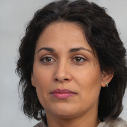 Joyful latino adult female with medium  brown hair and brown eyes