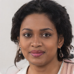 Joyful black young-adult female with long  brown hair and brown eyes