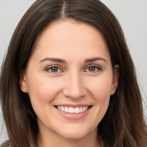 Joyful white young-adult female with long  brown hair and brown eyes