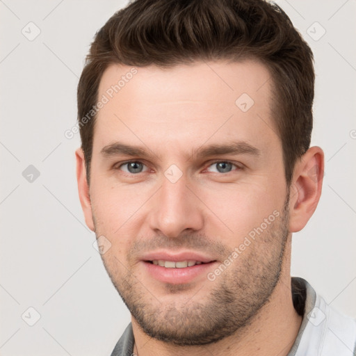 Joyful white young-adult male with short  brown hair and grey eyes