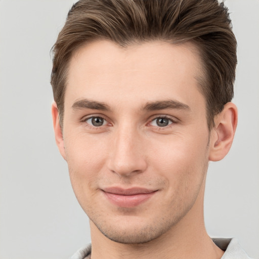 Joyful white young-adult male with short  brown hair and grey eyes