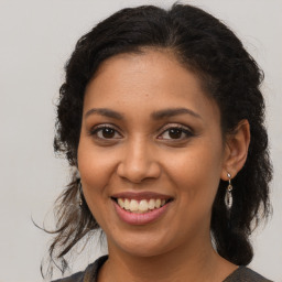 Joyful latino young-adult female with medium  brown hair and brown eyes