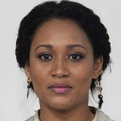 Joyful black adult female with short  black hair and brown eyes