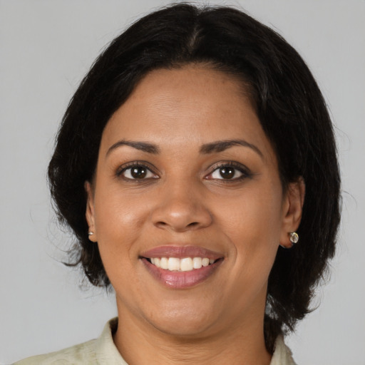 Joyful latino young-adult female with medium  brown hair and brown eyes