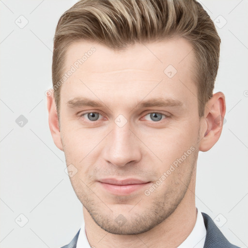 Joyful white young-adult male with short  brown hair and grey eyes