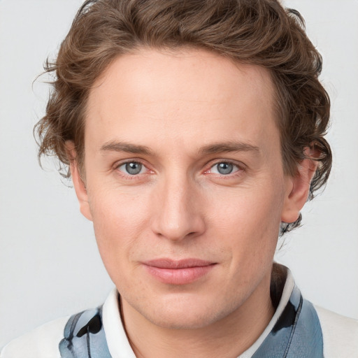 Joyful white young-adult male with short  brown hair and blue eyes