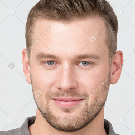 Joyful white young-adult male with short  brown hair and grey eyes