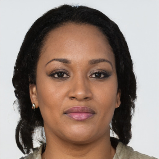 Joyful black young-adult female with long  brown hair and brown eyes