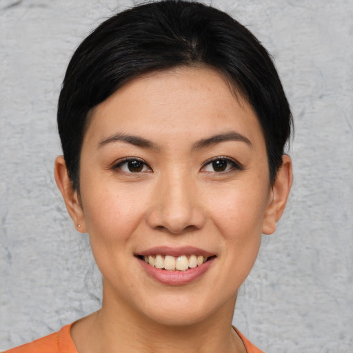 Joyful asian young-adult female with short  brown hair and brown eyes