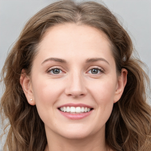 Joyful white young-adult female with long  brown hair and blue eyes