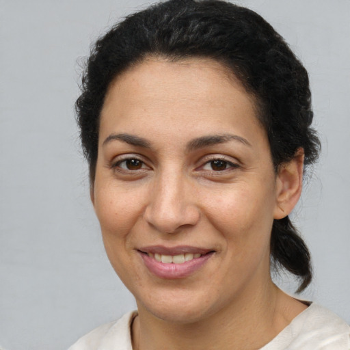 Joyful latino adult female with short  brown hair and brown eyes