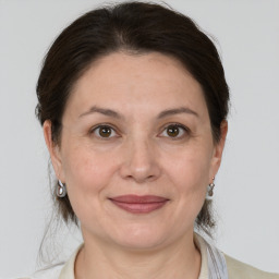 Joyful white adult female with medium  brown hair and grey eyes