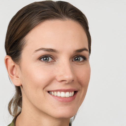 Joyful white young-adult female with medium  brown hair and grey eyes