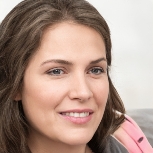 Joyful white young-adult female with medium  brown hair and blue eyes