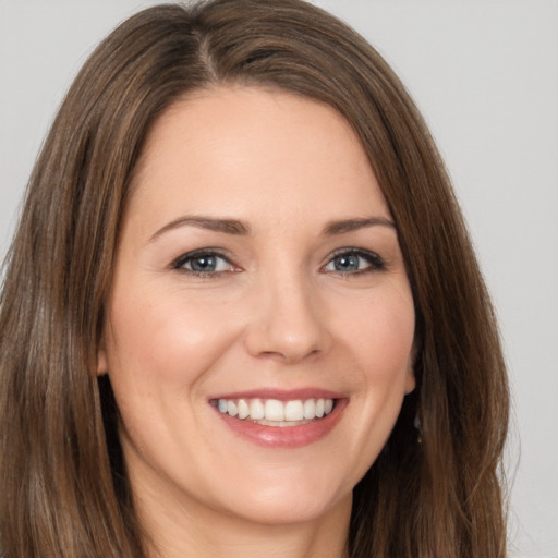 Joyful white young-adult female with long  brown hair and brown eyes