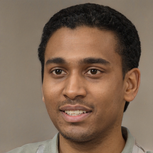 Joyful black young-adult male with short  black hair and brown eyes