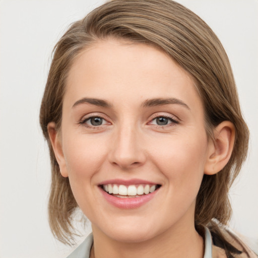 Joyful white young-adult female with medium  brown hair and blue eyes