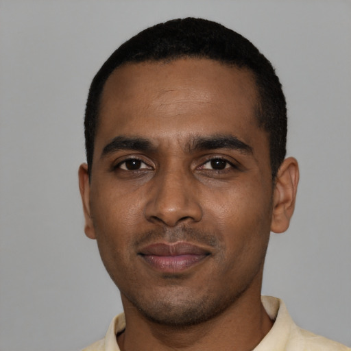 Joyful black young-adult male with short  black hair and brown eyes