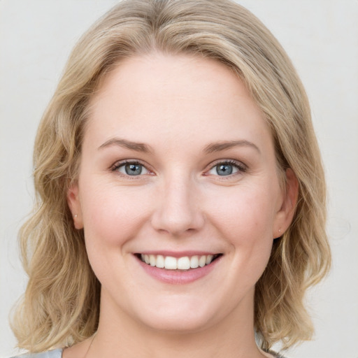 Joyful white young-adult female with medium  brown hair and blue eyes