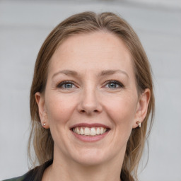 Joyful white adult female with medium  brown hair and grey eyes