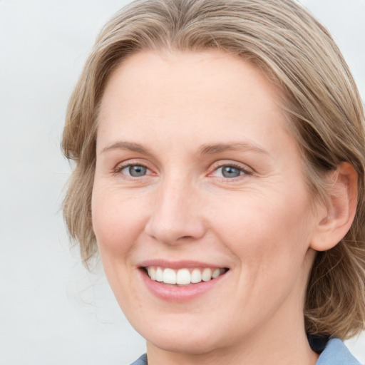 Joyful white young-adult female with medium  brown hair and blue eyes