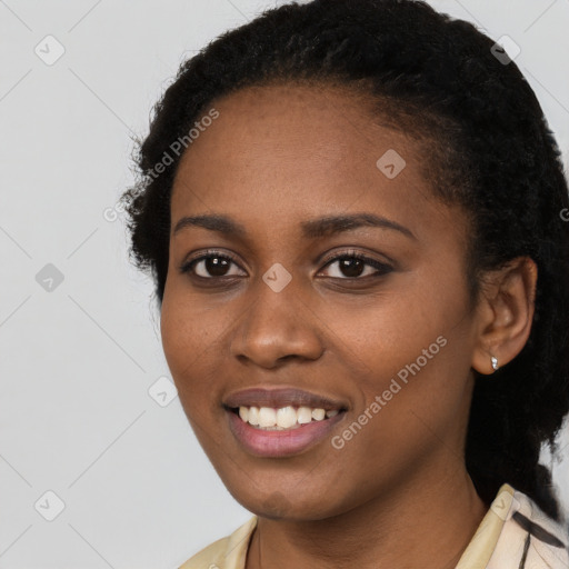 Joyful black young-adult female with long  black hair and brown eyes