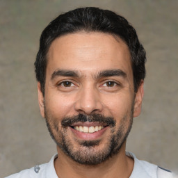 Joyful latino adult male with short  black hair and brown eyes