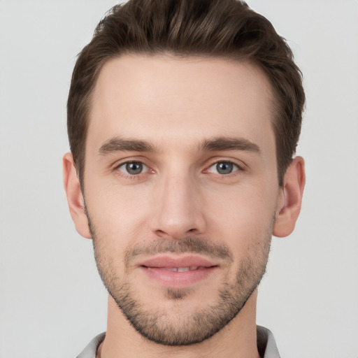 Joyful white young-adult male with short  brown hair and grey eyes