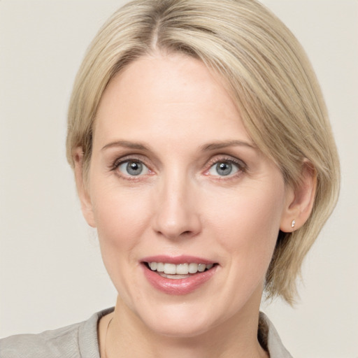 Joyful white adult female with medium  brown hair and grey eyes