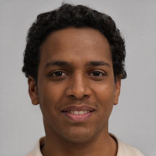 Joyful black young-adult male with short  brown hair and brown eyes