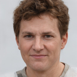 Joyful white adult male with short  brown hair and grey eyes