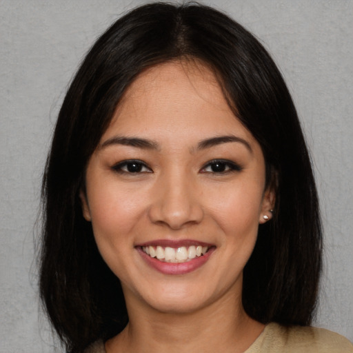 Joyful asian young-adult female with long  brown hair and brown eyes